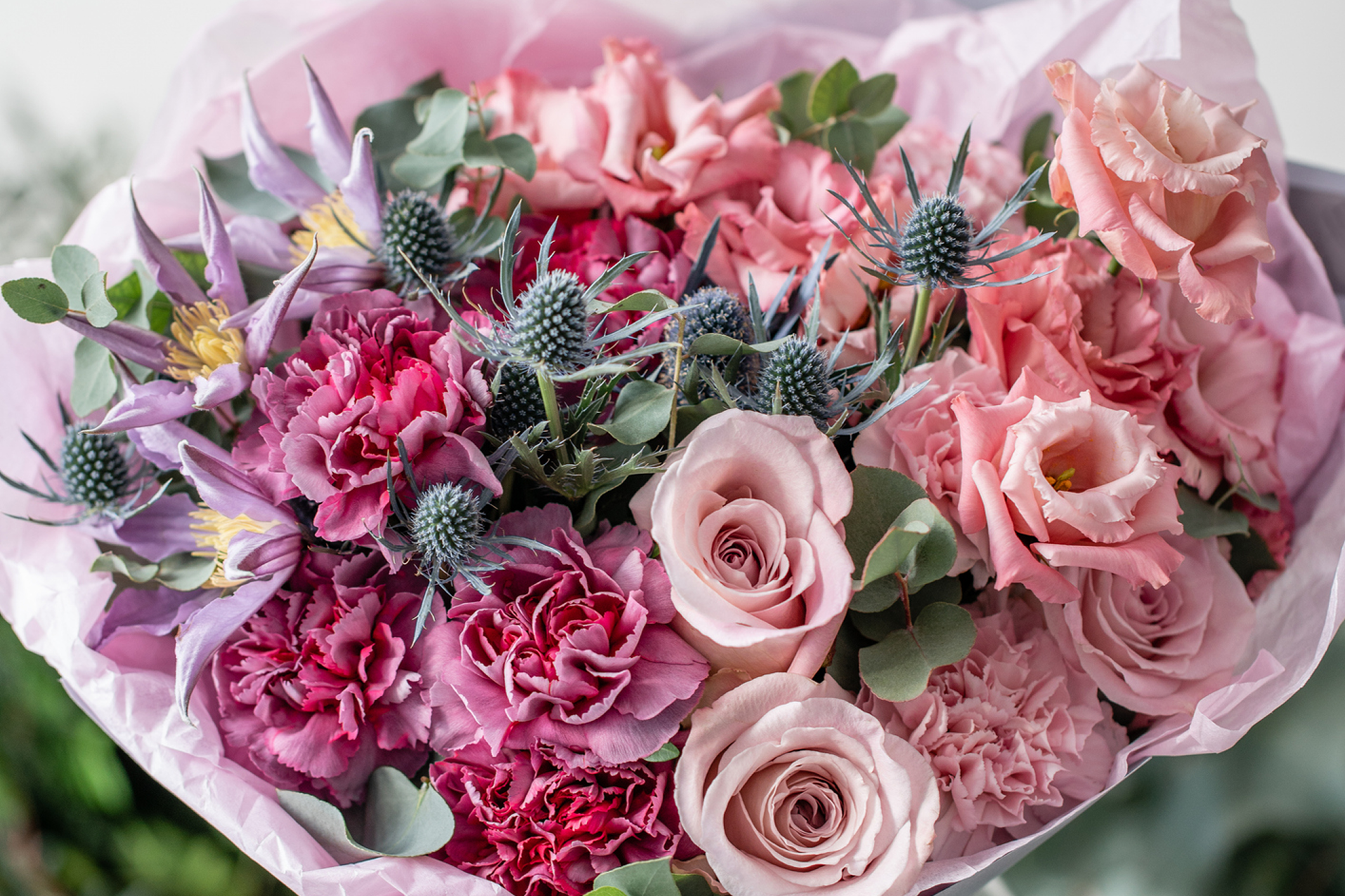 Pink and purple floral bouquet with greenery.