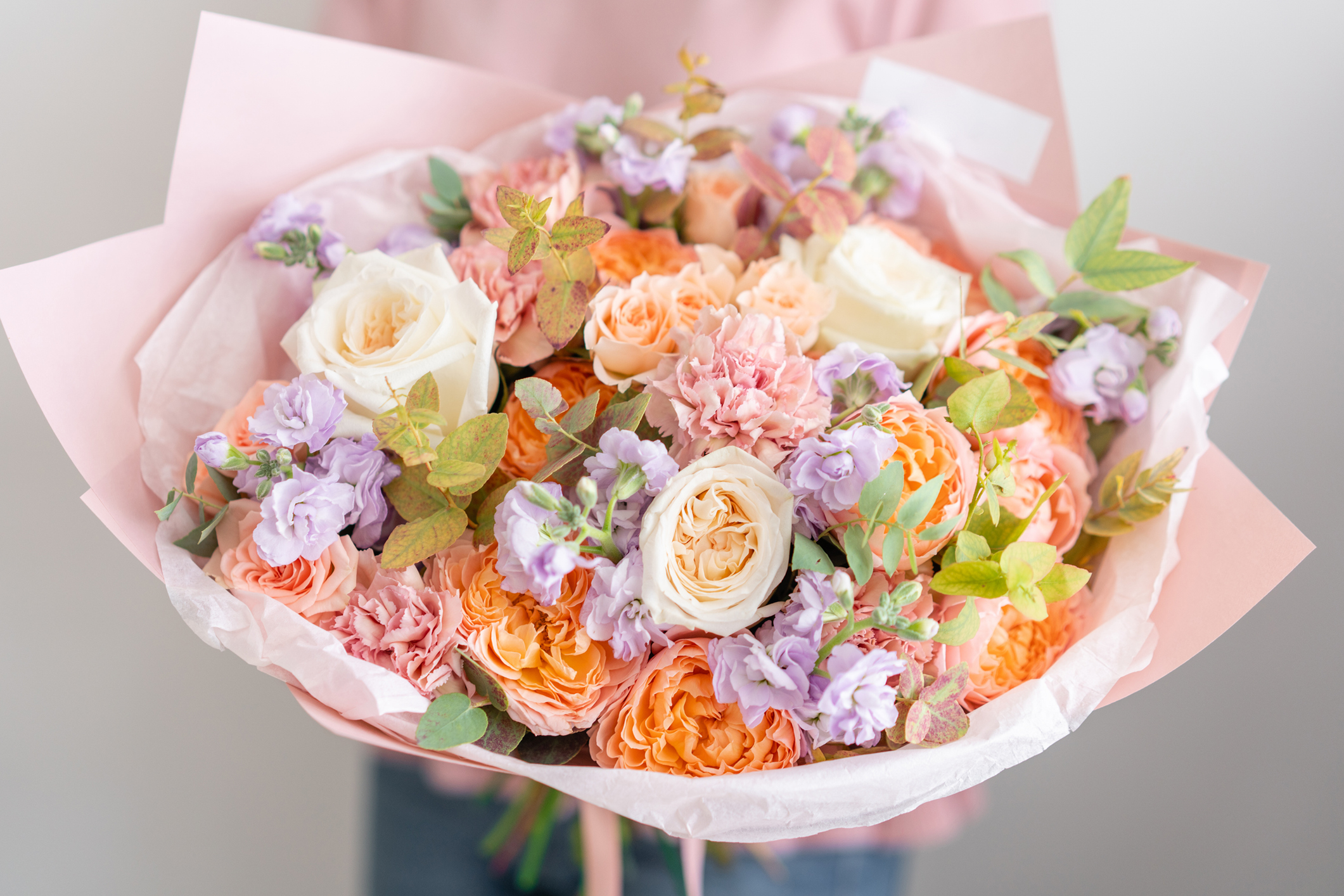 Bouquet of mixed pastel flowers and leaves.