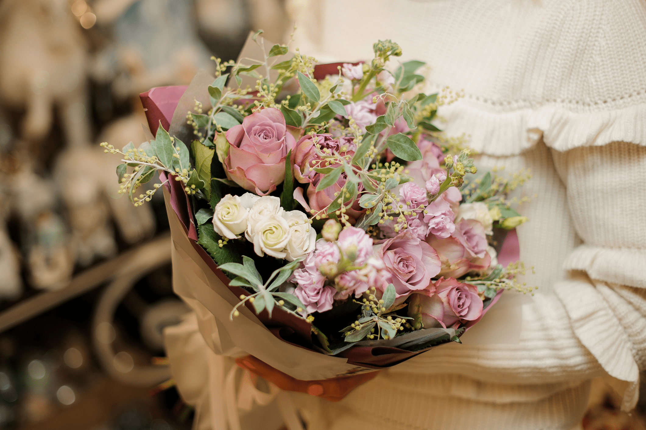 Bouquet of pink and white roses held.