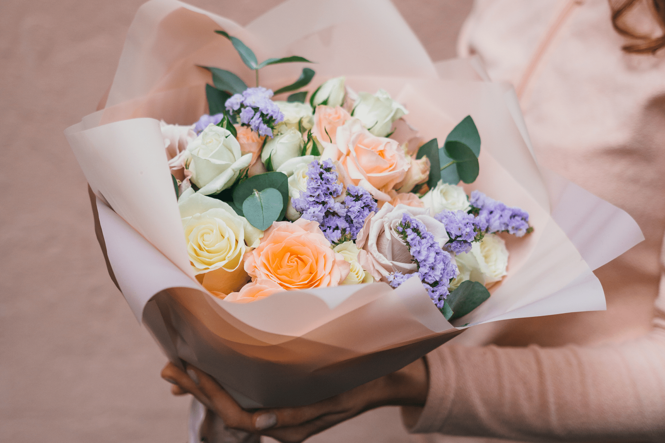 Bouquet of pastel flowers with greenery.