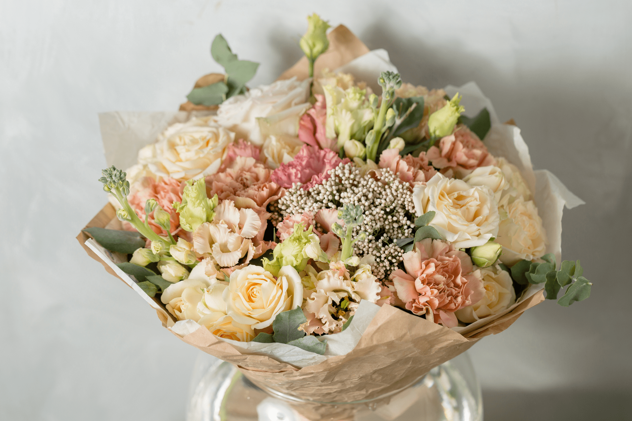 Bouquet of mixed pastel flowers on table.