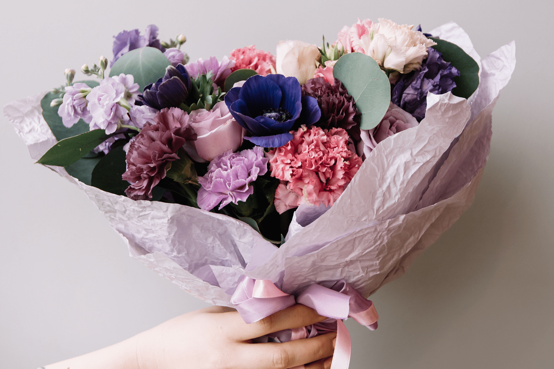 Bouquet of colorful flowers with purple wrapping.