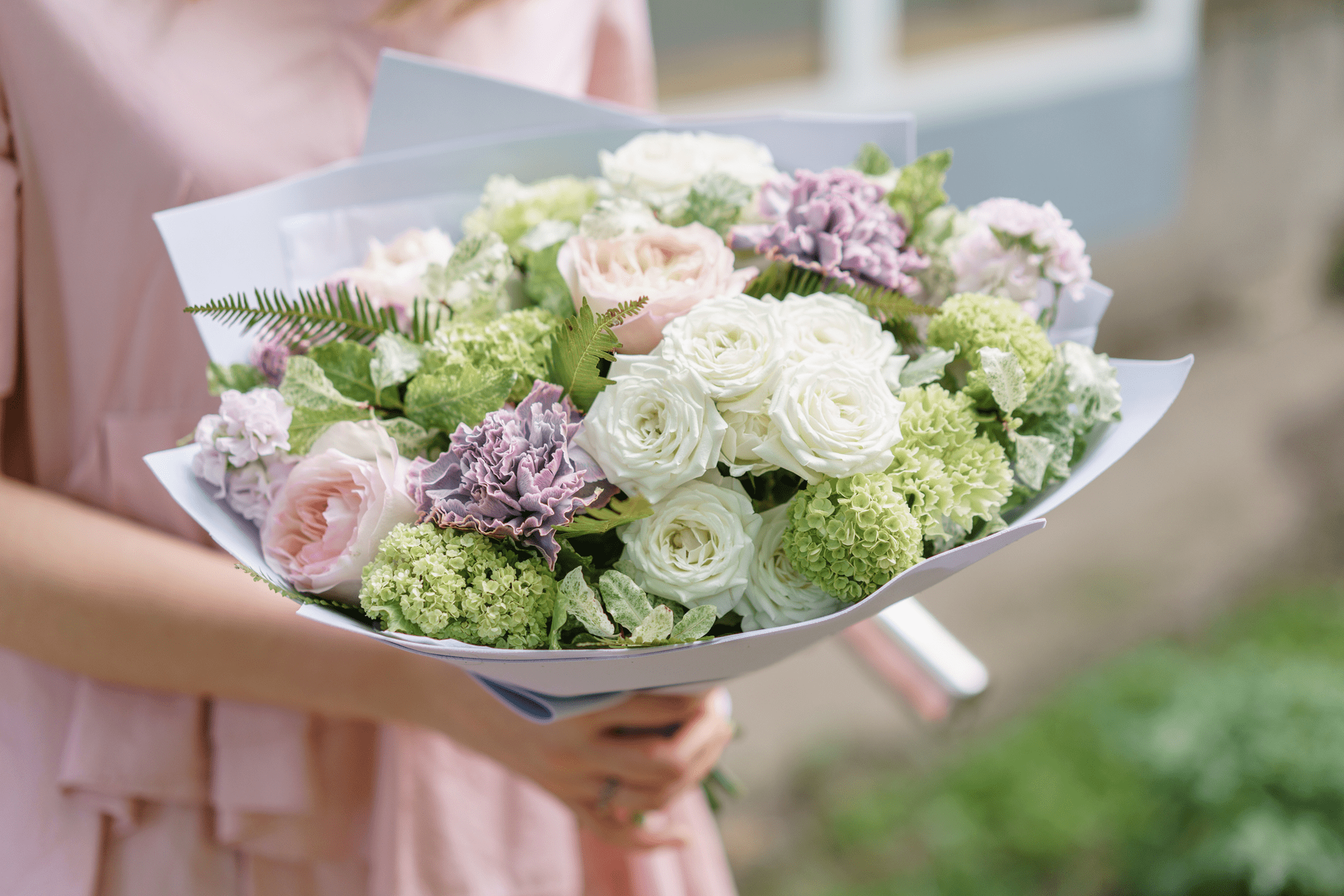 Bouquet of pastel flowers being held.